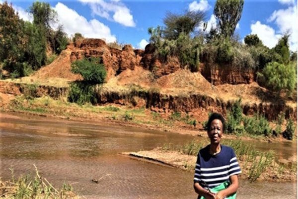 The image shows effect after the destruction of Sanga ya nzelu dam. The soil erosion seen  is believed to be caused by the disappearance of the mythical snake. Standing in the picture is one of the researchers.  Source: field data 2021